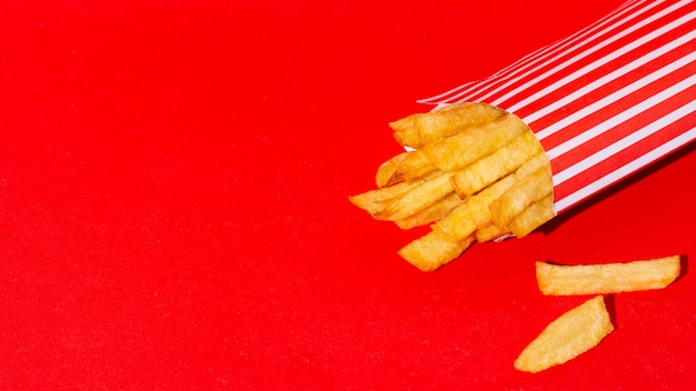 Papas fritas sobre fondo rojo.