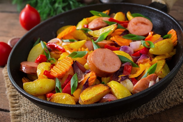 Papas fritas con verduras y salchichas.