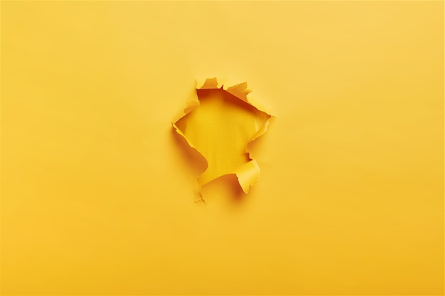 Papel amarillo rasgado con agujero en el centro