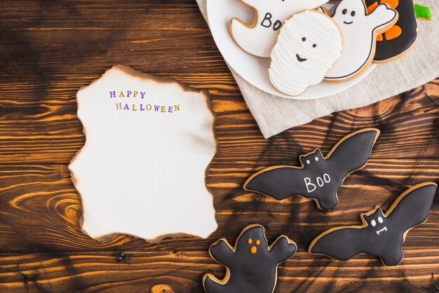 Papel ardiente cerca de pan de jengibre de Halloween en un plato