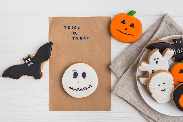 Papel artesanal alrededor de pan de jengibre de Halloween y galletas en un plato