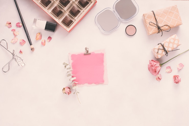 Foto gratuito papel en blanco con cajas de regalo, rosas y cosméticos.