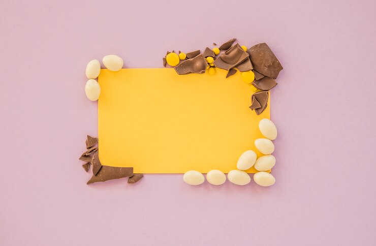 Foto gratuito papel en blanco con caramelos pequeños y chocolate rajado.