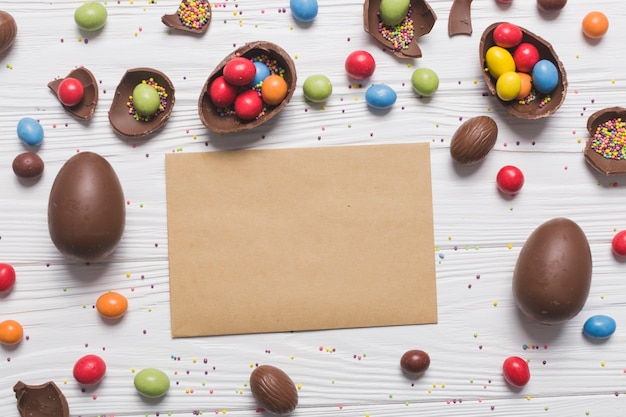 Foto gratuita papel en blanco entre dulces de pascua