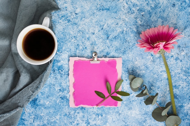 Papel en blanco con flor de gerbera y café