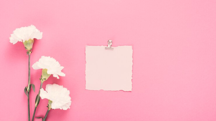 Foto gratuito papel en blanco con flores blancas en mesa