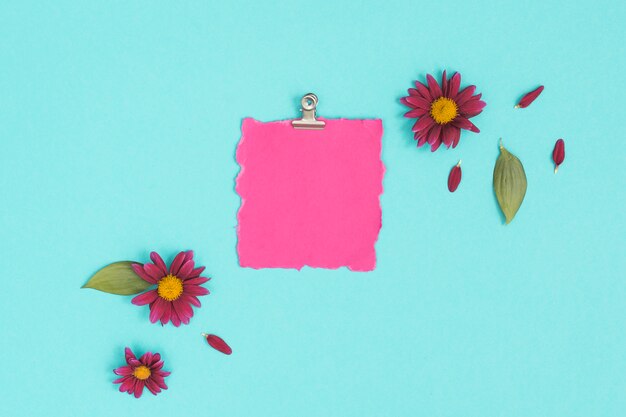 Papel en blanco con flores en la mesa