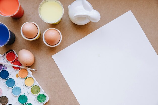 Papel en blanco y huevos con colores