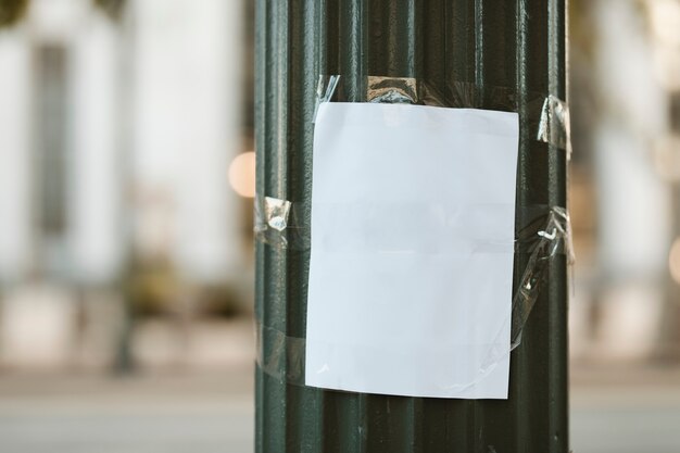 Papel en blanco pegado en un pilar verde