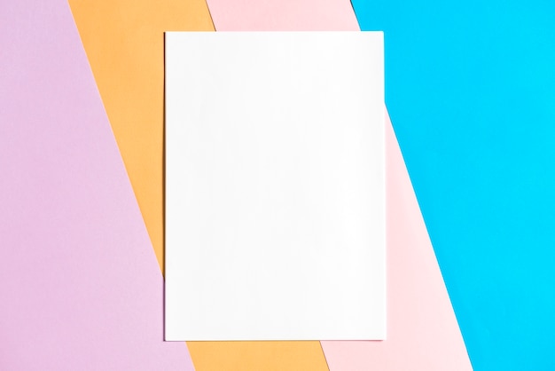 Papel en blanco sobre fondo de papeles coloridos