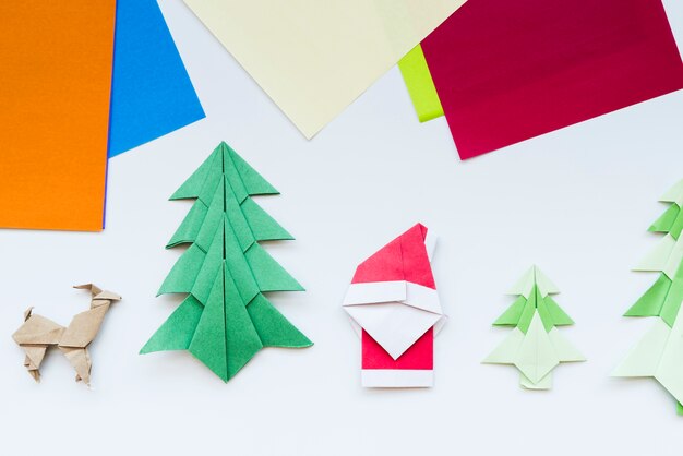 Papel colorido y árbol de navidad hecho a mano; reno; Papá Noel origami de papel aislado sobre fondo blanco