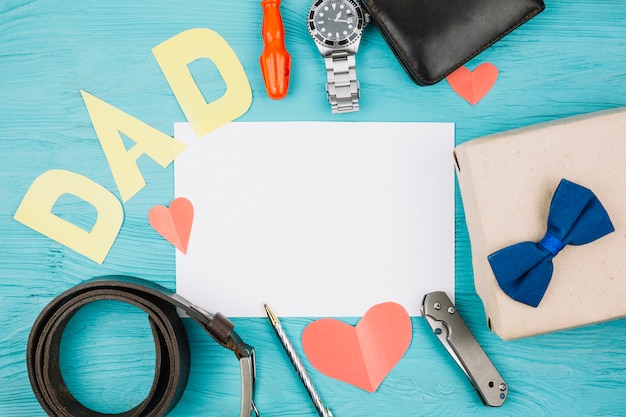 Papel entre corazones rojos y título de papá cerca de accesorios masculinos.