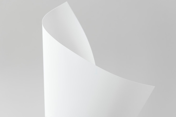 Foto gratuito papel doblado en blanco sobre un fondo gris