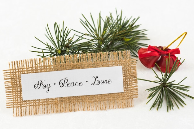 Papel con inscripción Joy Peace Love en mesa.