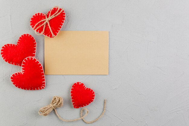 Papel marrón en blanco entre corazones de peluche