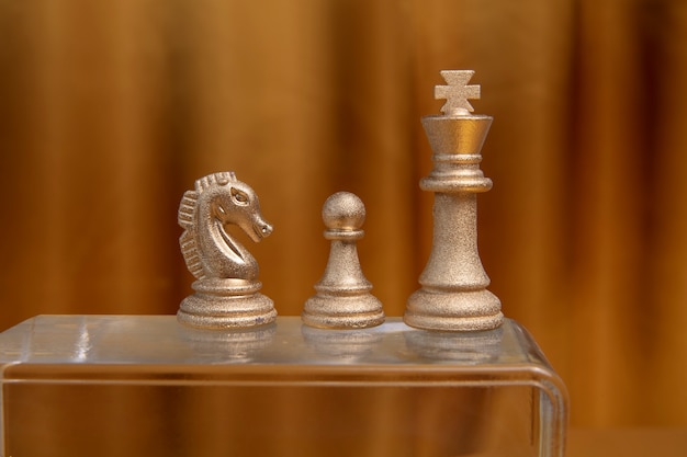 Papel pintado estético dorado con piezas de ajedrez.