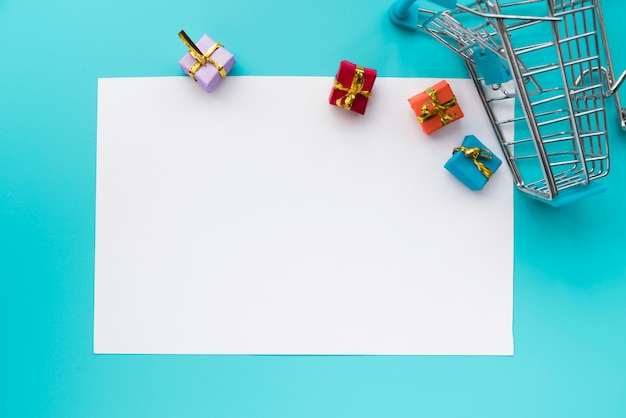 Papel rodeado de regalos y carrito de la compra