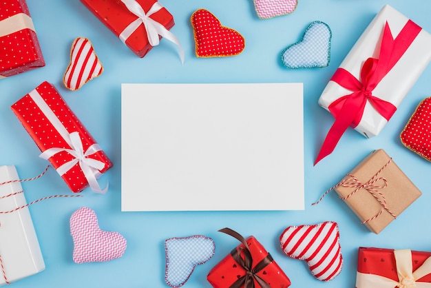 Papel entre set de cajas de regalo y corazones de juguete.