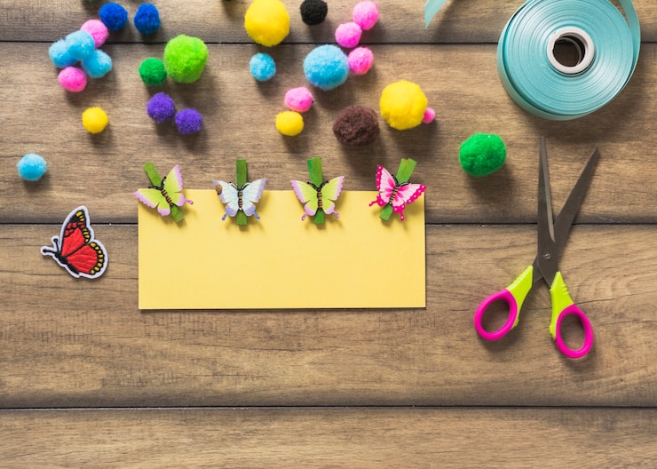 Foto gratuito papel de tarjeta amarilla decorado con mariposas sobre fondo de madera