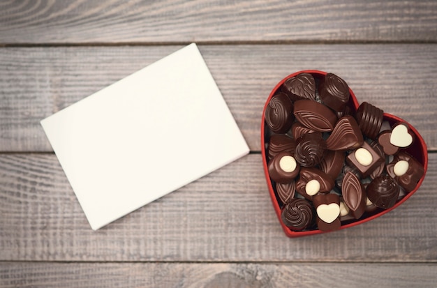 Foto gratuita papel vacío y caja de chocolate abierta