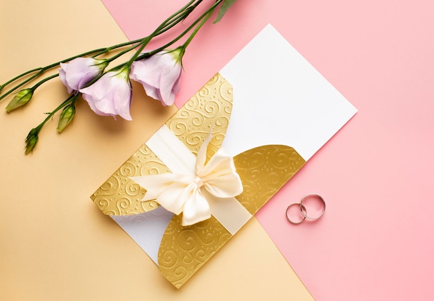 Papelería de boda de lujo con flores y anillos planos