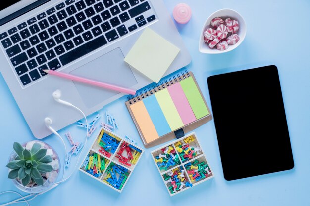 Papelería y dulces cerca de la tableta y computadora portátil