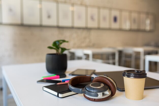 Papelería de oficina diferente dispuesta en mesa blanca en oficina de trabajo conjunto