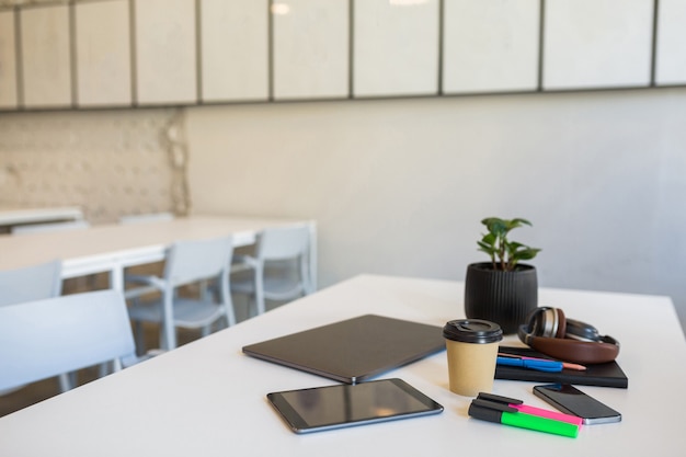 Papelería de oficina diferente dispuesta en mesa blanca en oficina de trabajo conjunto