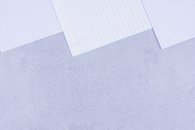 Papeles en blanco aislados en superficie gris