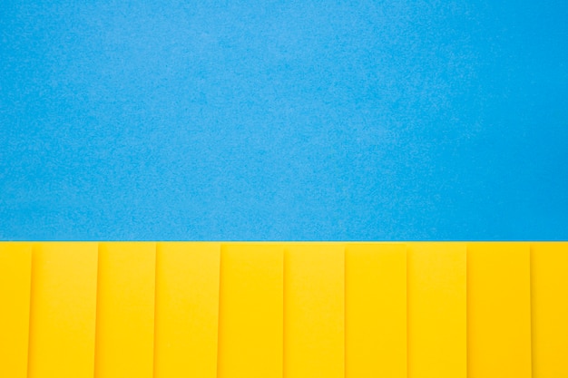 Papeles de cartón amarillo en una fila sobre fondo azul
