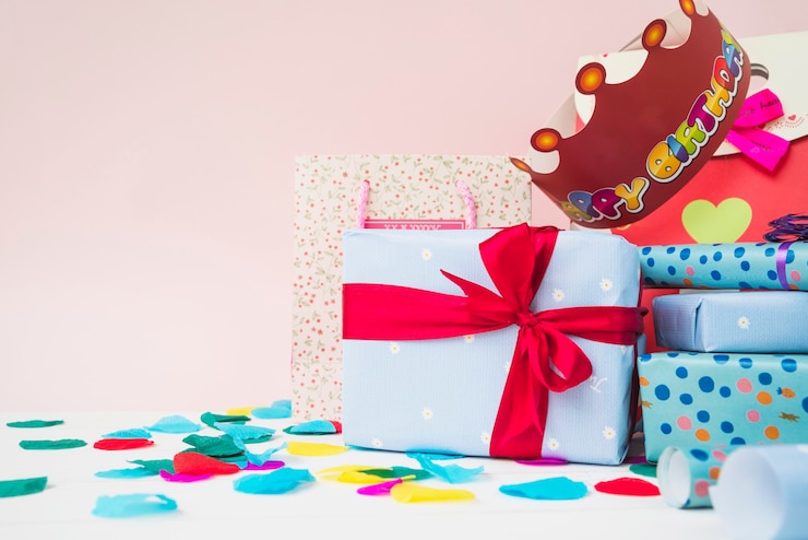 Photo Gratis paper crown over the present gift boxes on table against pink background