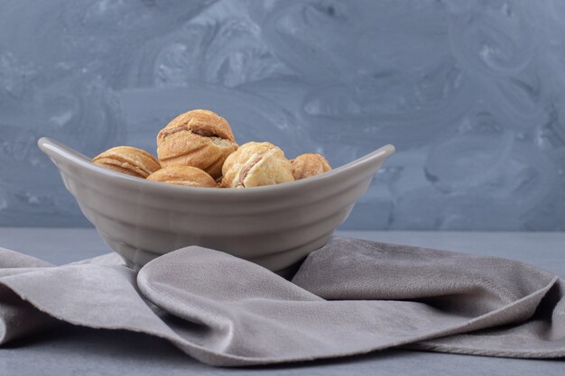 Paquete de bolas de galleta rellenas de caramelo en un recipiente sobre mármol