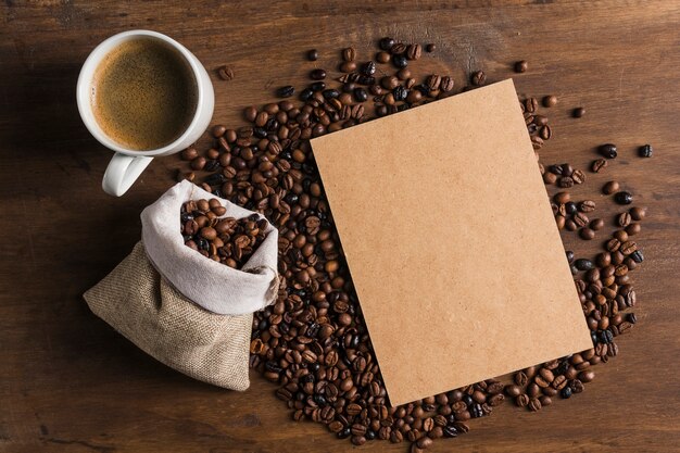 Paquete cerca de taza y saco con granos de café.