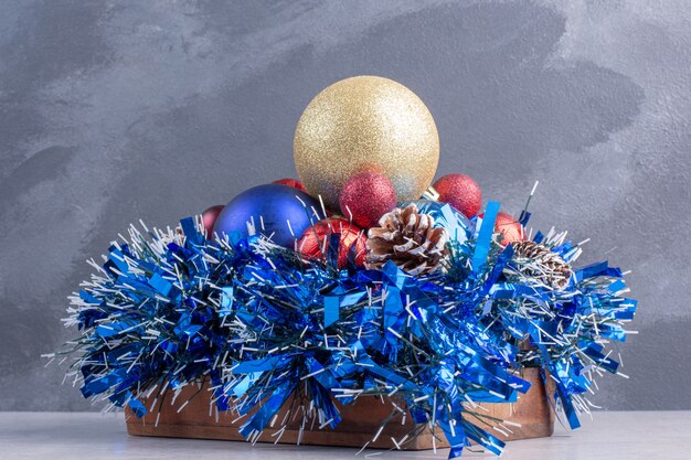 Paquete de diversas decoraciones navideñas en una tabla de madera sobre superficie de mármol