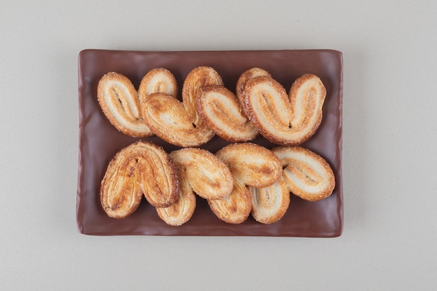 Foto gratuita paquete de galletas escamosas en un plato sobre fondo blanco.