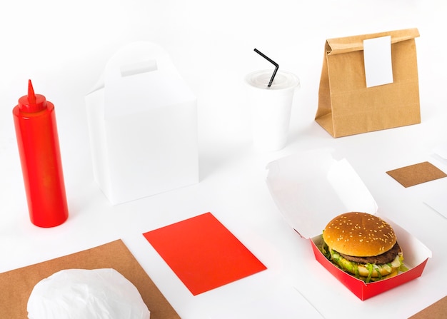 Paquete; hamburguesa; Maqueta de salsa y vaso desechable sobre fondo blanco