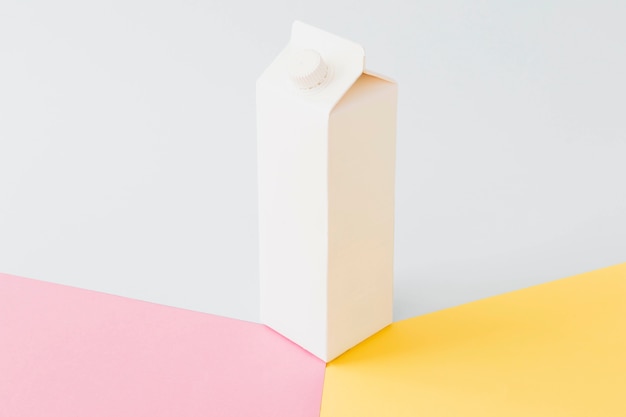 Paquete de leche de cartón blanco en tablero brillante