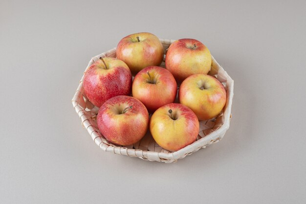 Un paquete de manzanas en una canasta de mármol