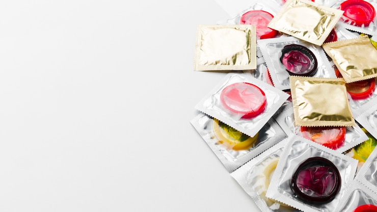 Foto gratuito paquetes de condones sobre fondo blanco con espacio de copia