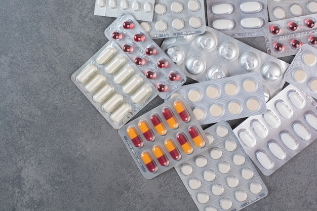Paquetes surtidos de medicamentos en superficie de mármol.