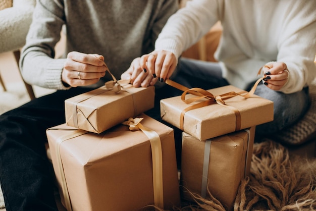 Par abriendo regalos de Navidad por el árbol