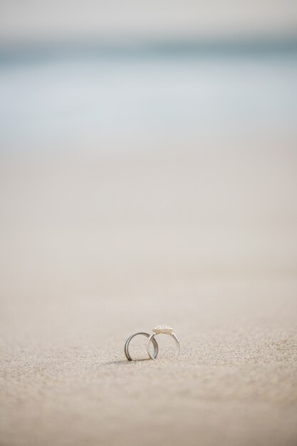 Par de anillo de bodas en la arena