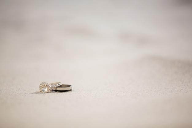 Par de anillo de bodas en la arena