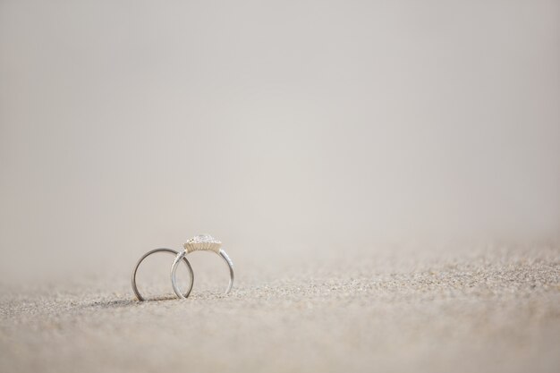 Par de anillo de bodas en la arena