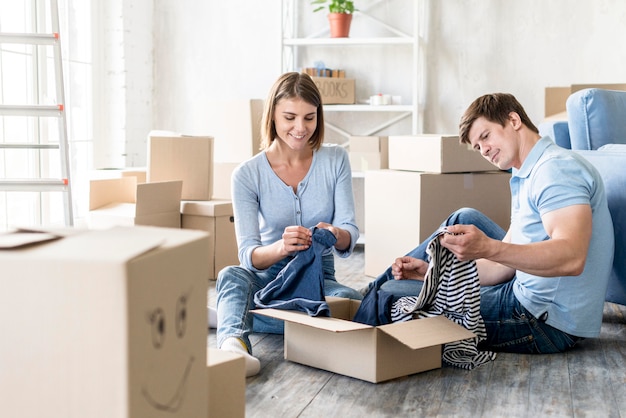 Foto gratuita par de cajas de embalaje con ropa para mudarse