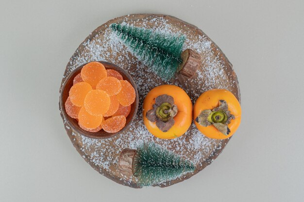 Par de caquis frescos con mermeladas de naranja.