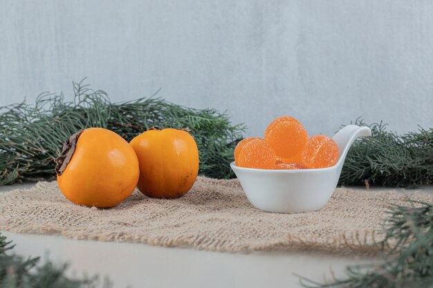 Par de caquis frescos con mermeladas de naranja.