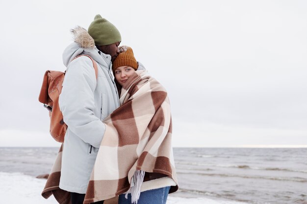 Par despertar juntos en la playa durante un viaje por carretera de invierno