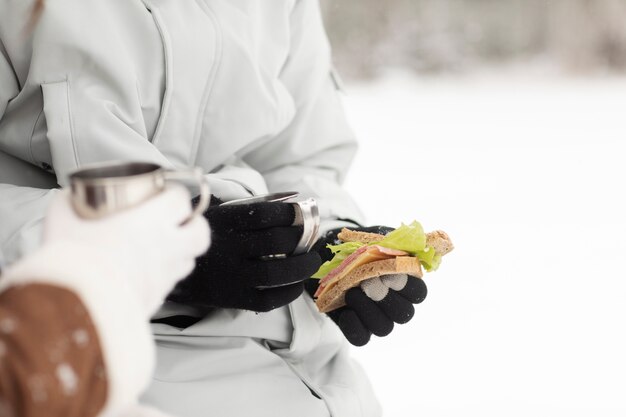 Par disfrutar de bebidas calientes y un sándwich durante un viaje por carretera en invierno