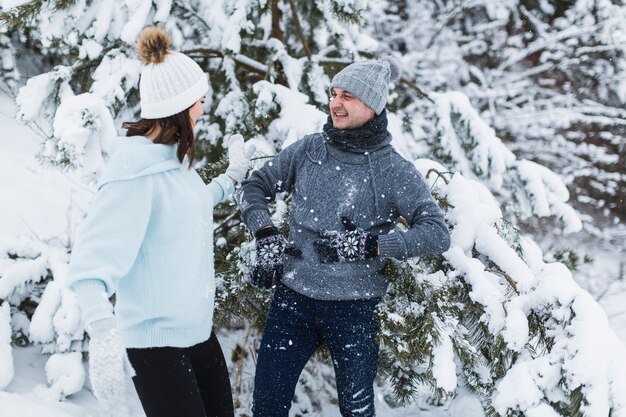 Par divirtiéndose en el bosque de invierno